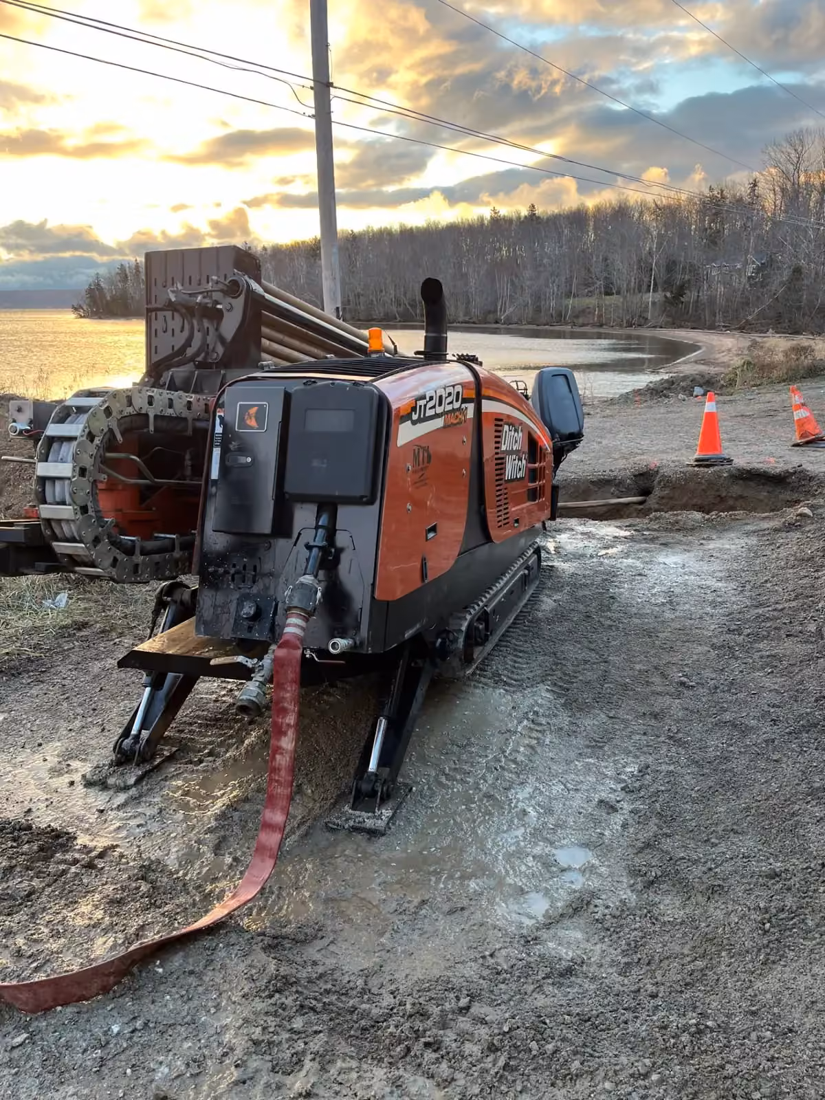 Directional drill rig working a shoreline installation at sunset