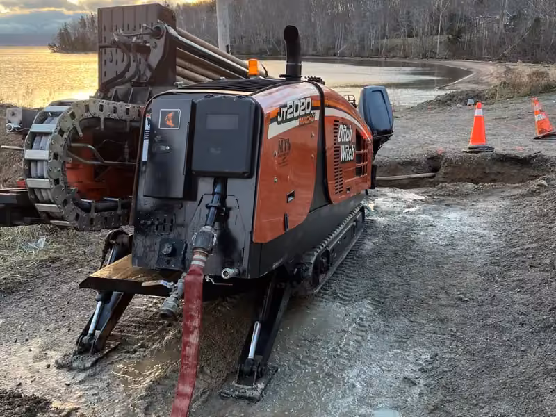 Directional drill rig working a shoreline installation at sunset
