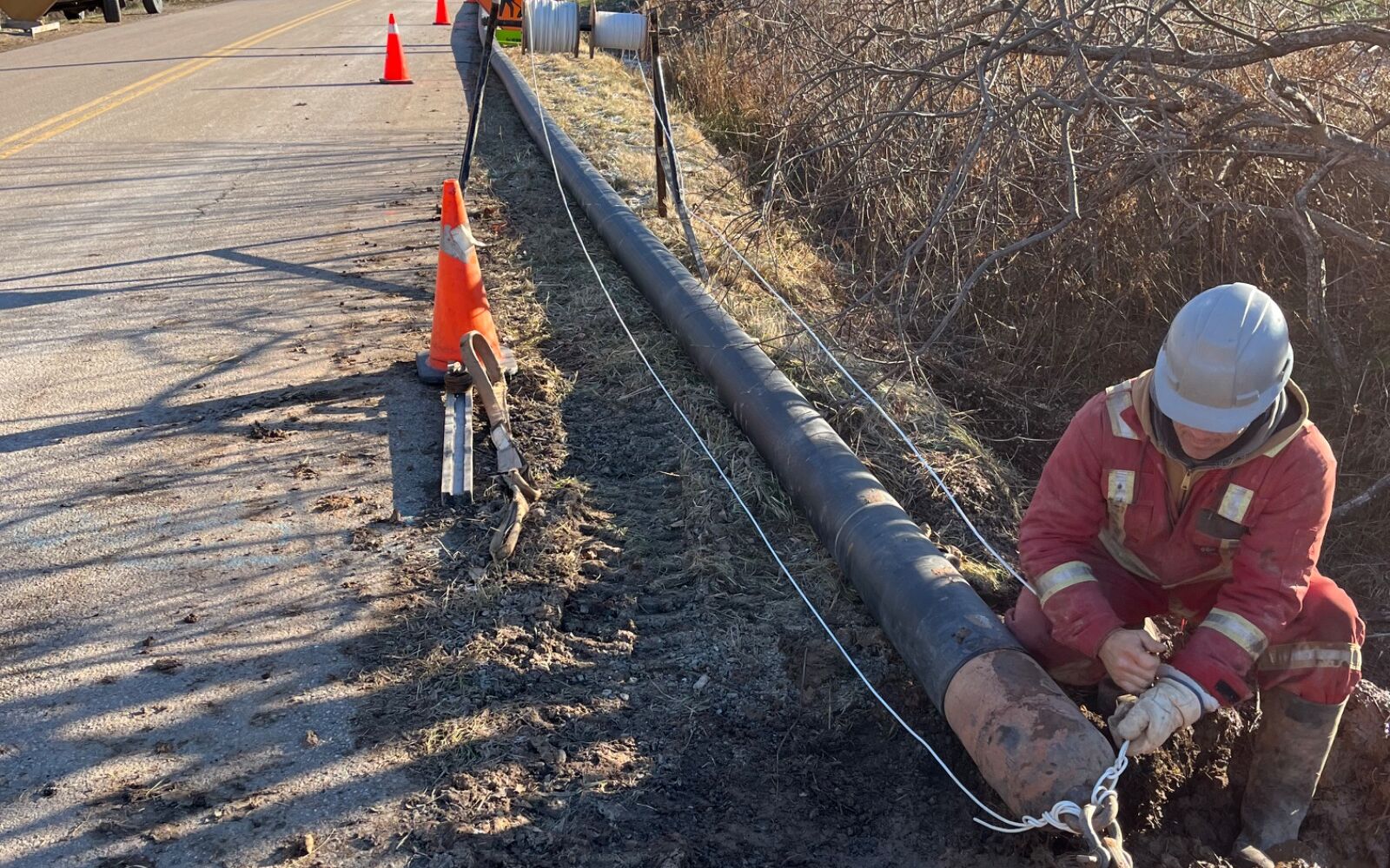 WM Directional Drilling crew pulling HDPE pipe on a rural road